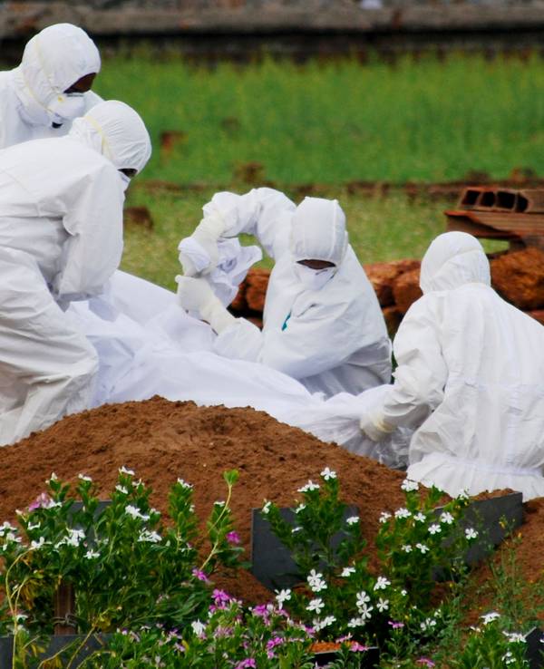 Rettungssanitäter in Schutzanzügen begraben ein Opfer, das aufgrund des Nipah-Virus verstarb.