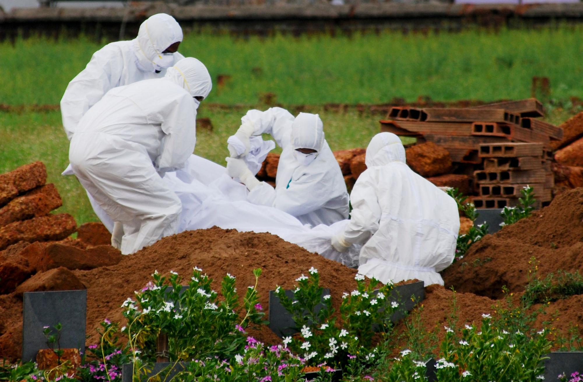 Rettungssanitäter in Schutzanzügen begraben ein Opfer, das aufgrund des Nipah-Virus verstarb.