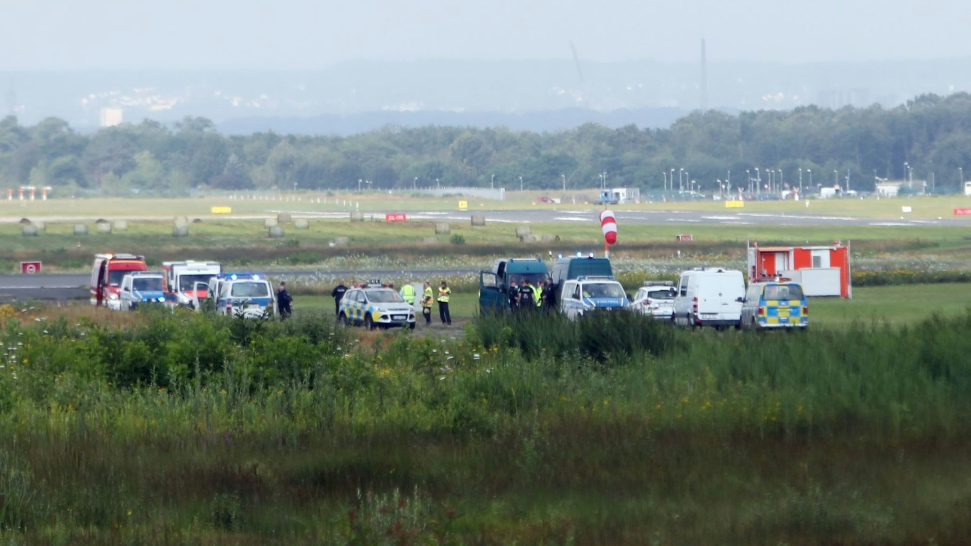 Viele Autos von Polizei und Feuerwehr stehen auf dem Rollfeld am Flughafen Köln/Bonn.