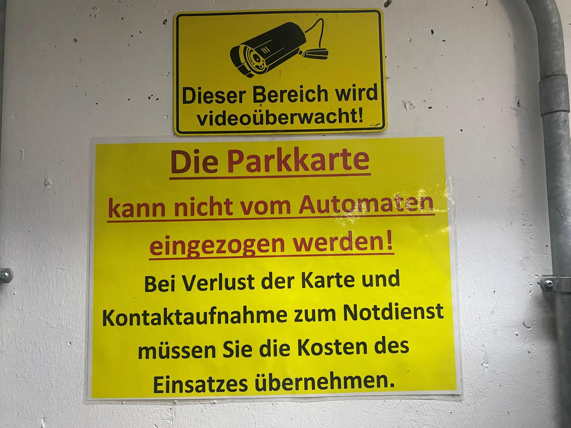 Schild mit Hinweisen neben einem Parkscheinautomaten.