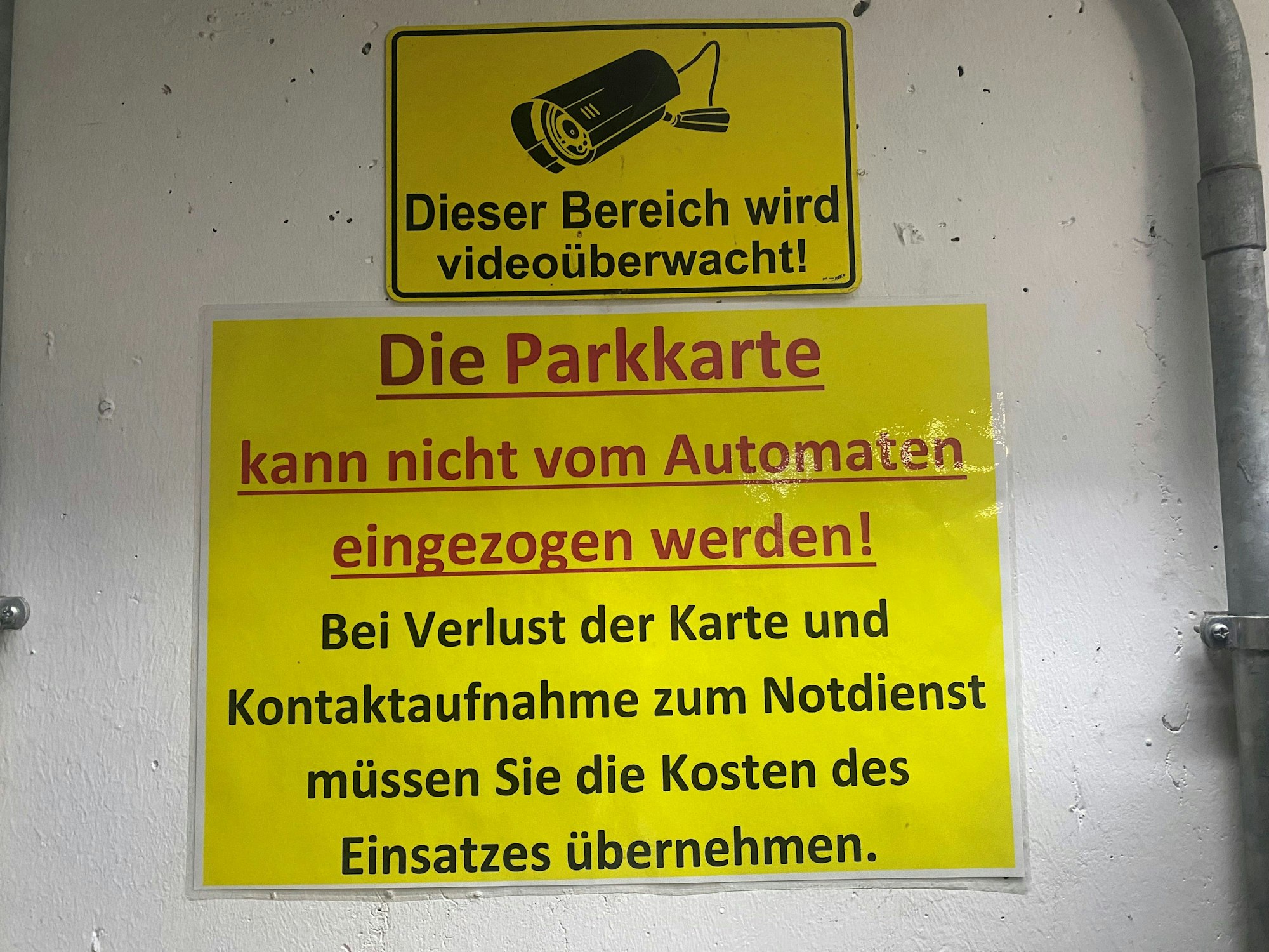 Schild mit Hinweisen neben einem Parkscheinautomaten.