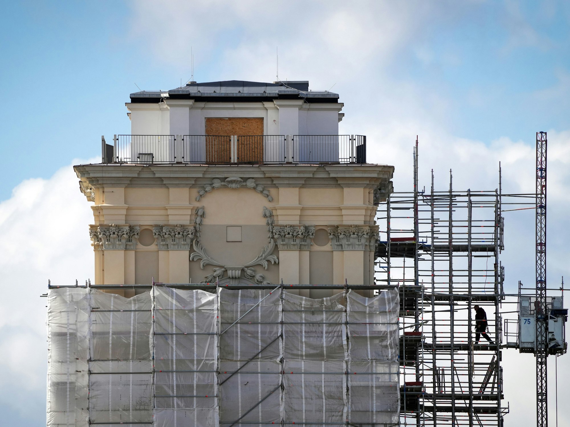 Ein Arbeiter geht vom Bauaufzug an der Garnisonkirche zum Turm.