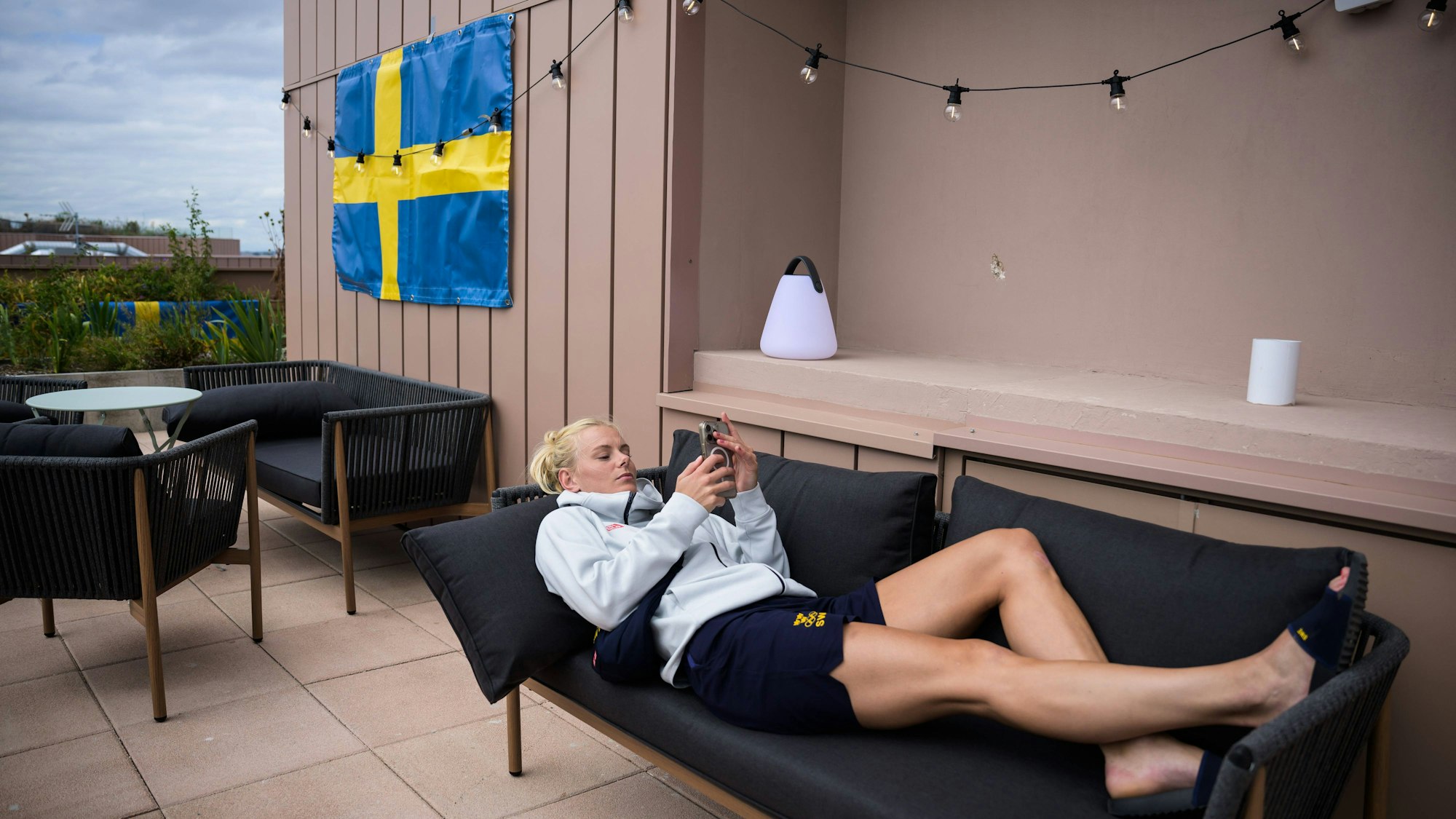 Die schwedische Handballerin Nina Koppang chilltauf einer Liege im Olympischen Dorf.