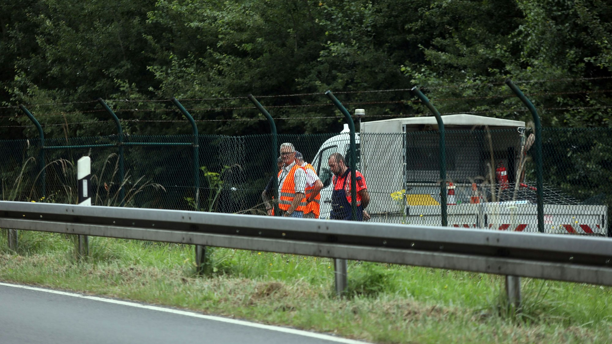 Mitarbeiter des Flughafens Köln/Bonn sichern den beschädigten Zaun, wo die Aktivisten sich Zugang verschafft haben.