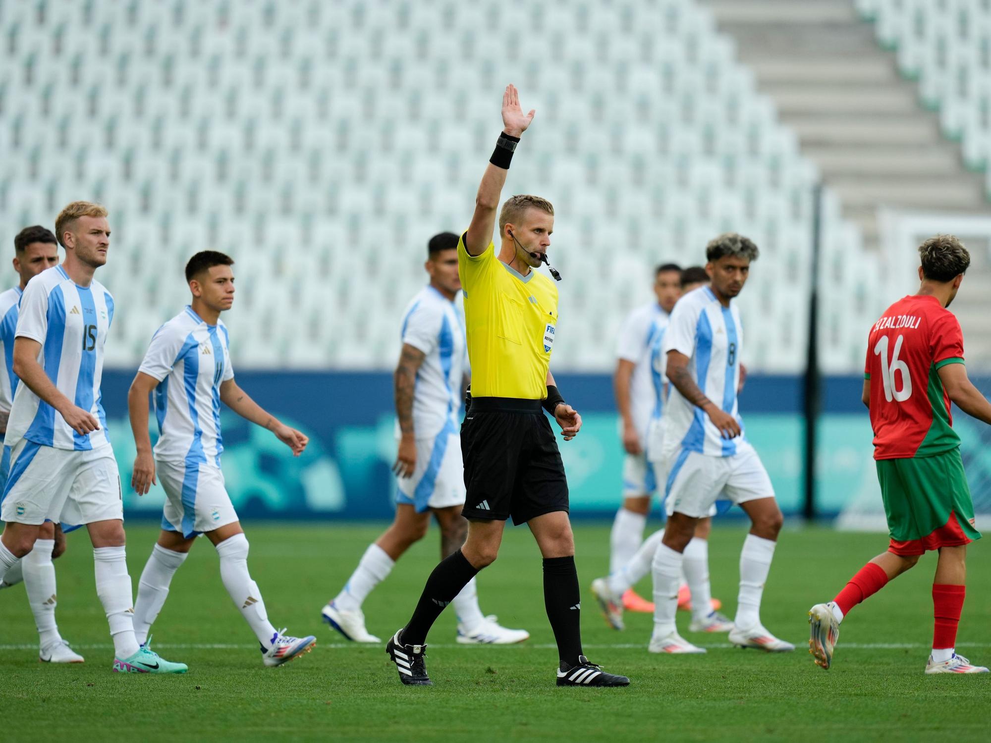 Schiedsrichter Glenn Nyberg entscheidet auf Abseits, umringt von den argentinischen Spielern.