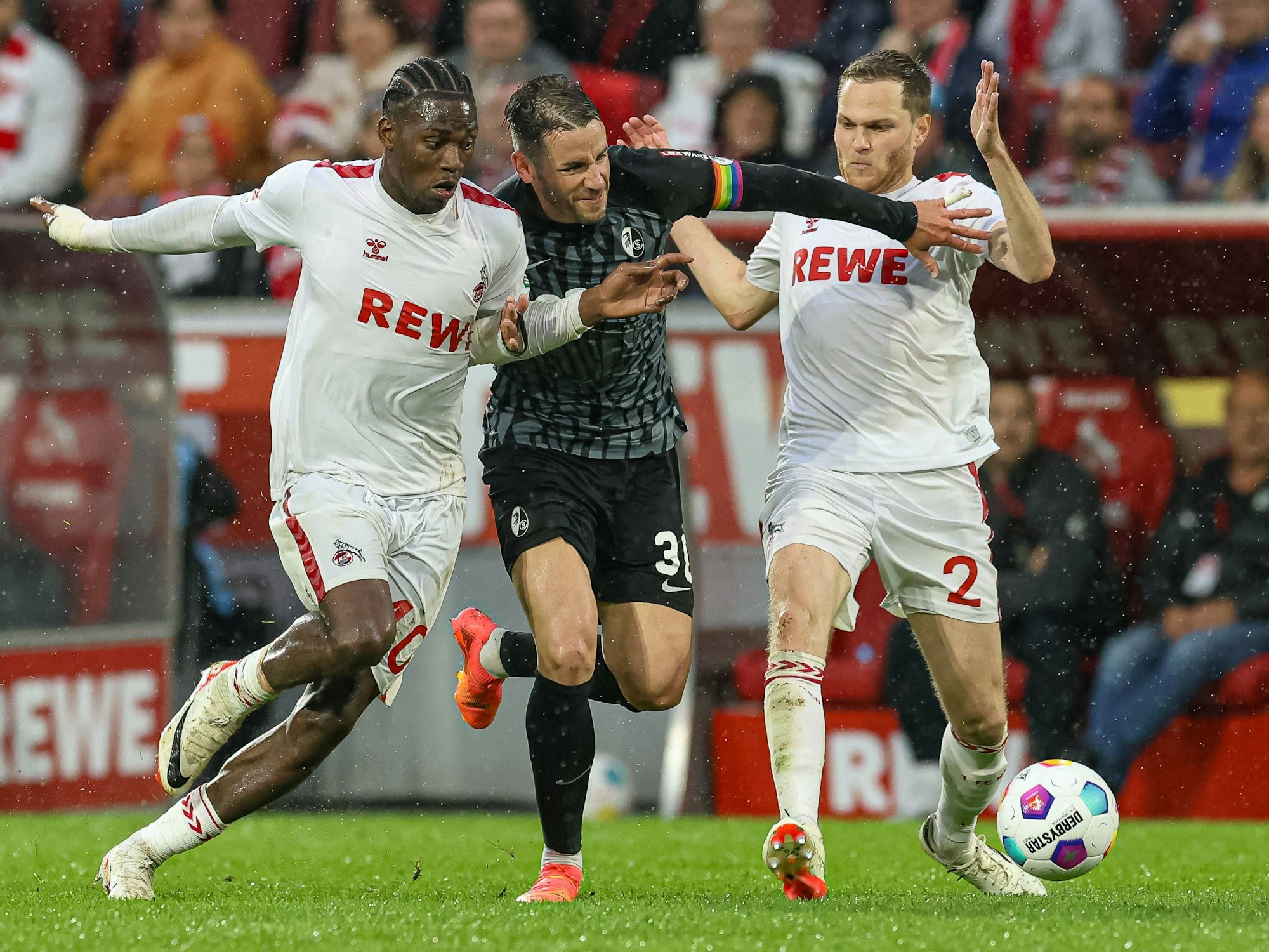 Faride Alidou (l.), Christian Günther und Benno Schmitz (r.) im Kampf um den Ball.