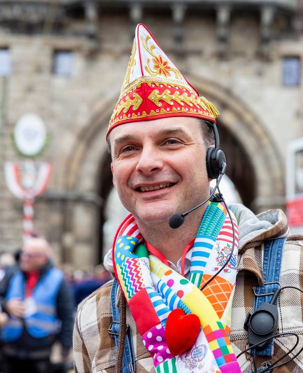 Zugleiter Holger Kirsch steht mit Schal und Mütze beim Rosenmontagszug 2020 in Köln.