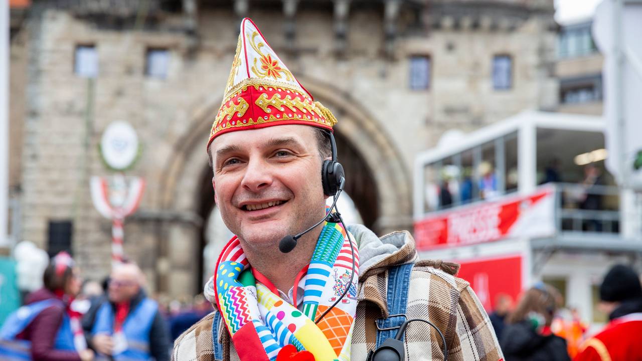 Zugleiter Holger Kirsch steht mit Schal und Mütze beim Rosenmontagszug 2020 in Köln.