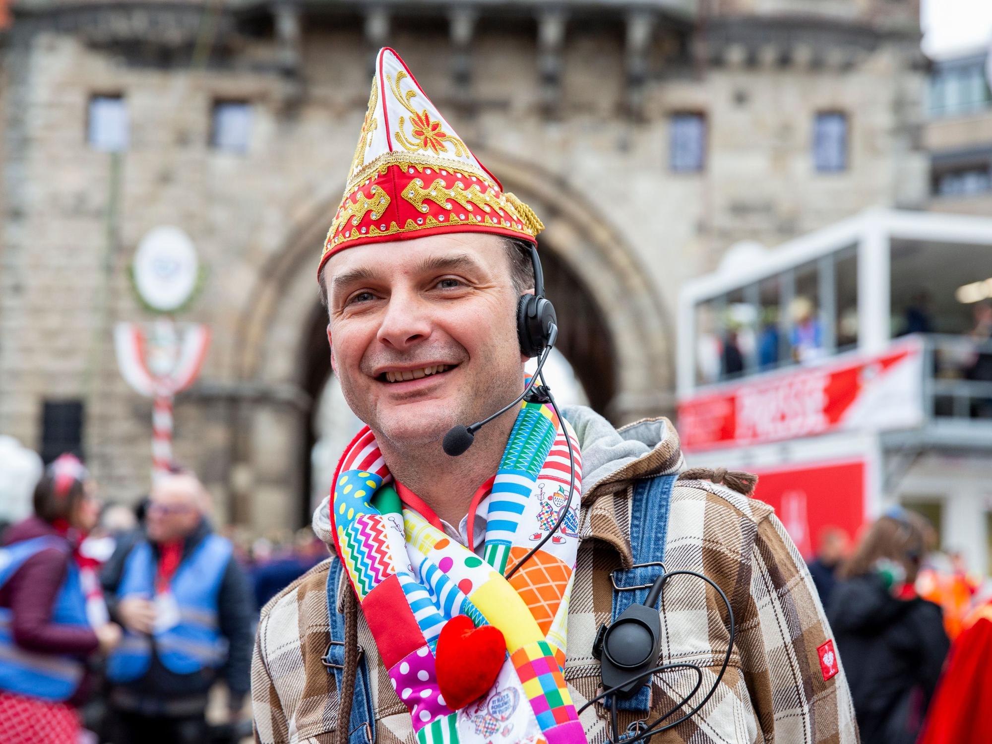 Zugleiter Holger Kirsch steht mit Schal und Mütze beim Rosenmontagszug 2020 in Köln.