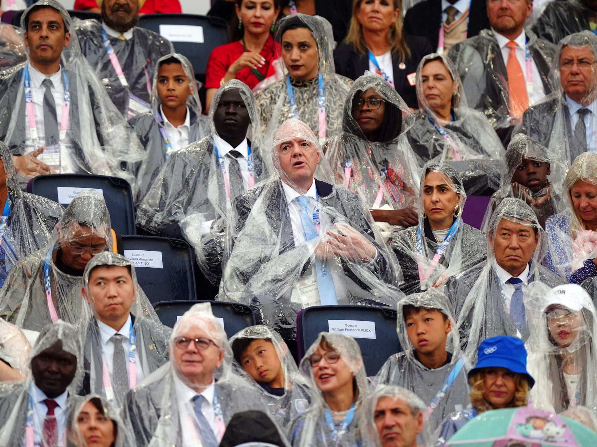 Auf den Tribünen waren Regenponchos das Pflicht-Accessoire während der Olympia-Eröffnungsfeier – auch bei prominenten Gästen wie Fifa-Präsident Gianni Infantino (Mitte).