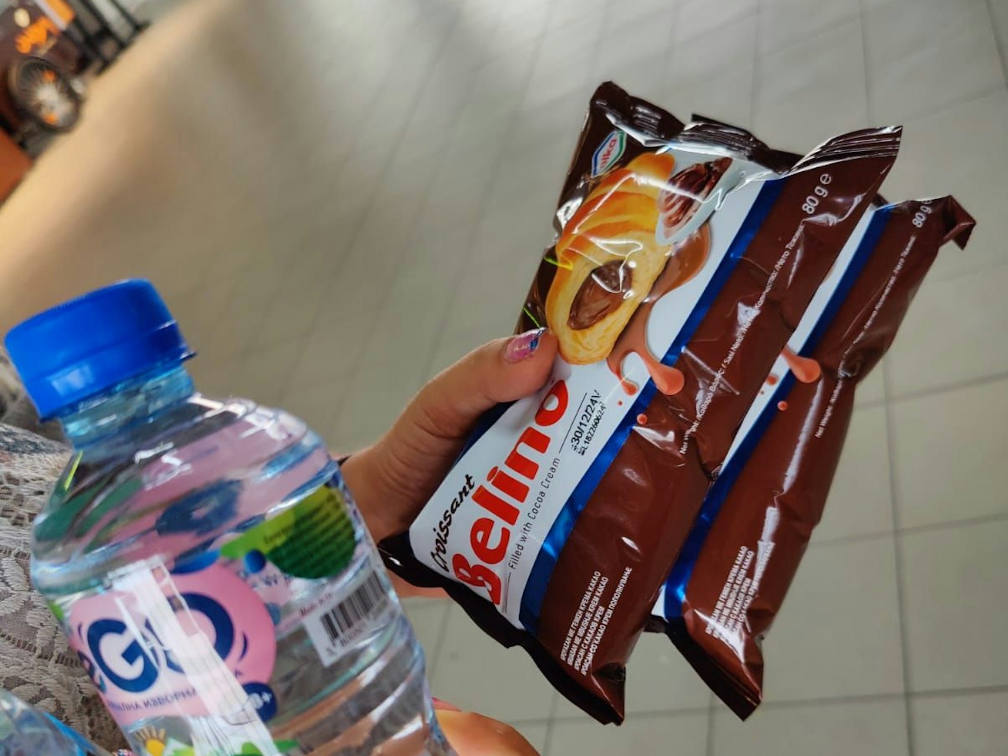 Eine Frau hält Schokoweckchen und Wasser in der Hand.