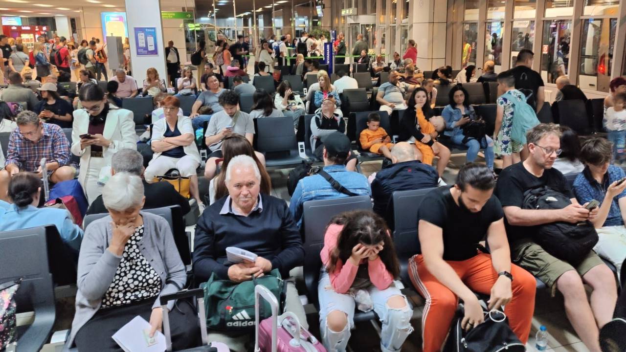 Menschen sitzen in einem Flughafen-Gate.