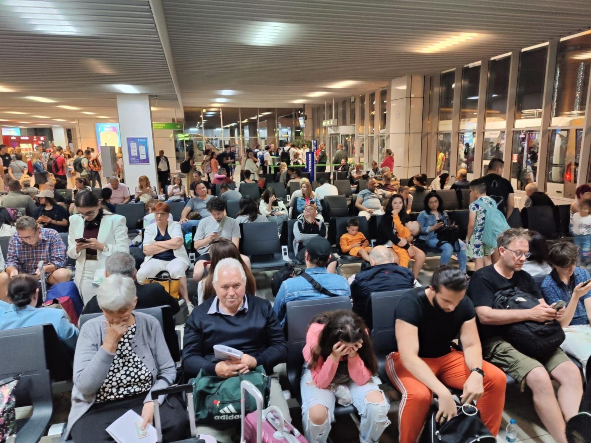 Menschen sitzen in einem Flughafen-Gate.