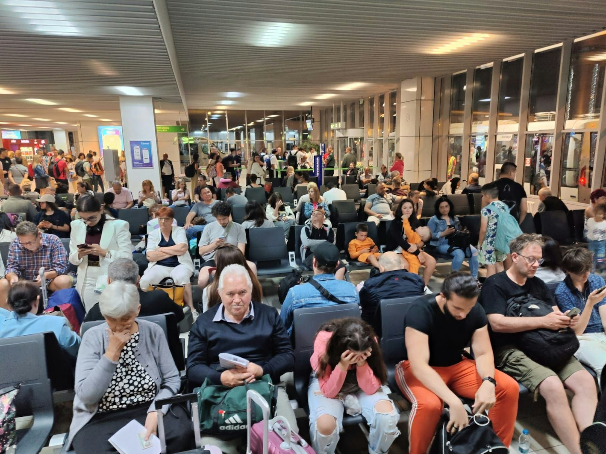 Menschen sitzen in einem Flughafen-Gate.