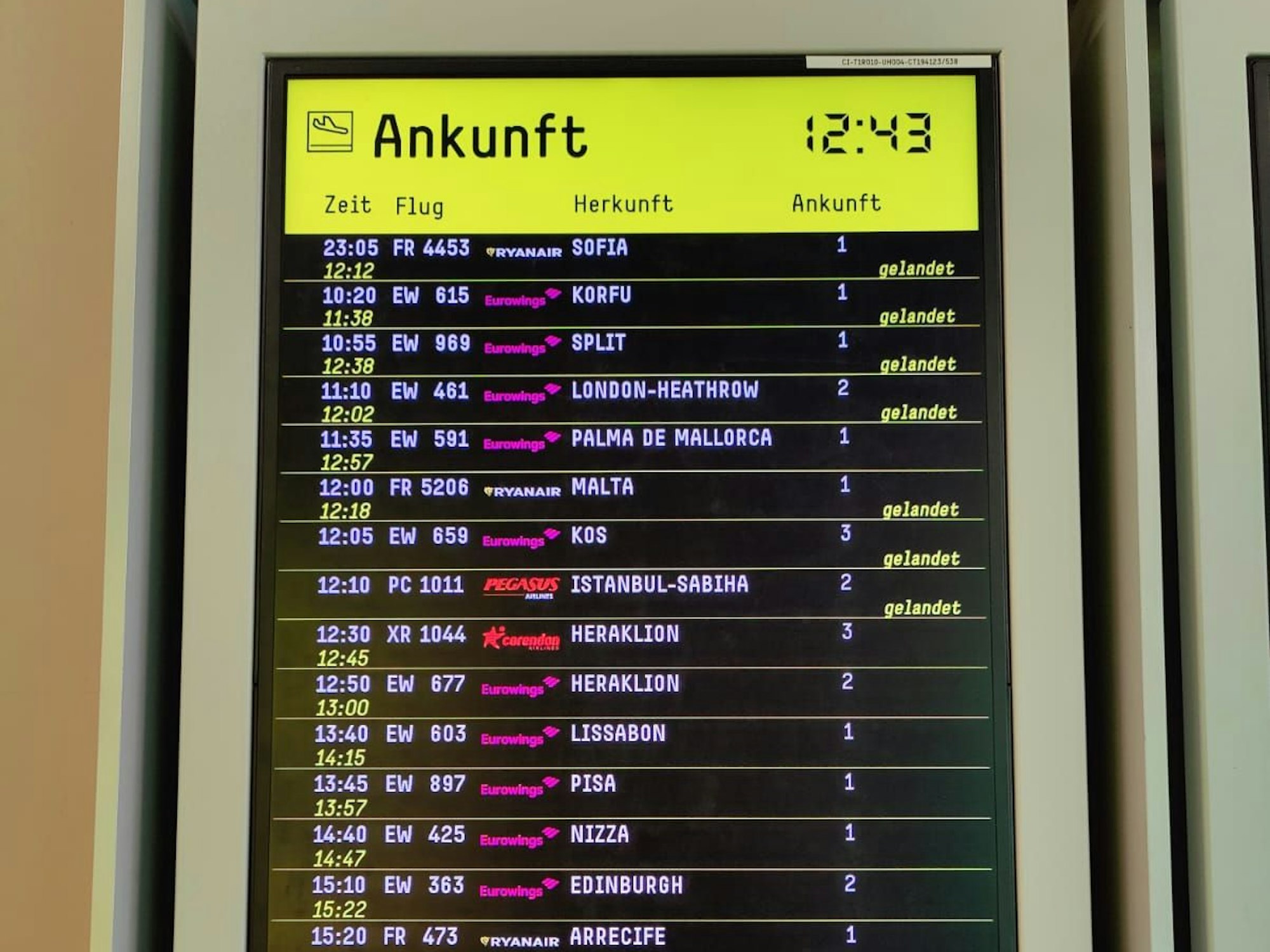 Eine digitale Tafel zeigt die Ankunftszeiten von Flugzeugen.