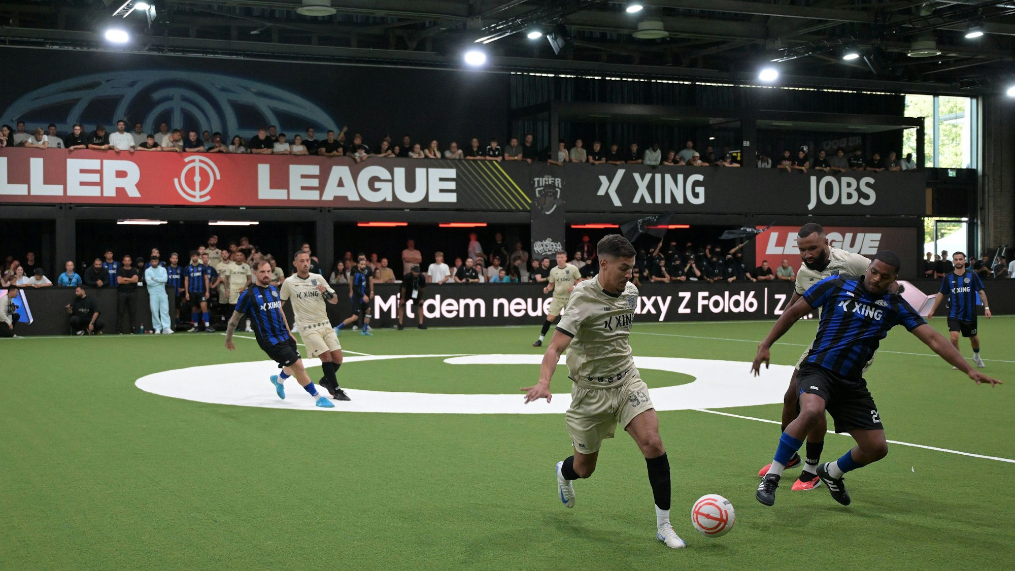 Zwei Teams spielen in einer Halle gegeneinander eine Partie der Baller League.