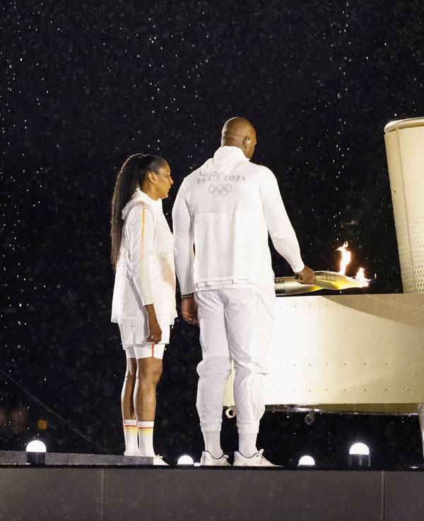 Marie-José Pérec und Teddy Riner entzünden das olympische Feuer.