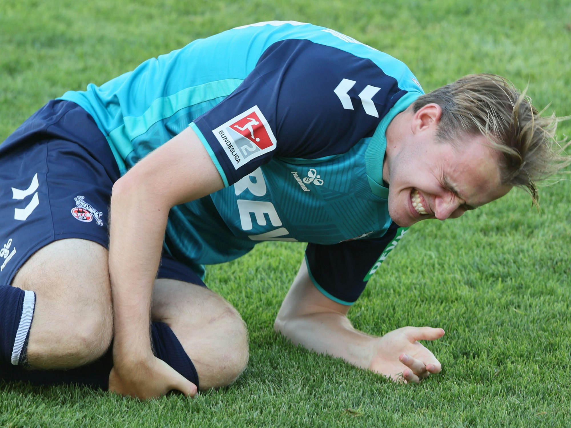 Jacob Christensen hält sich mit schmerzverzerrtem Gesicht das Knie.