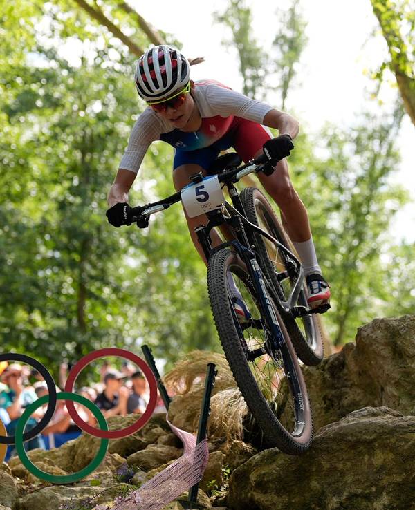 Loana Lecomte fährt auf dem Mountainbike durchs Gelände.