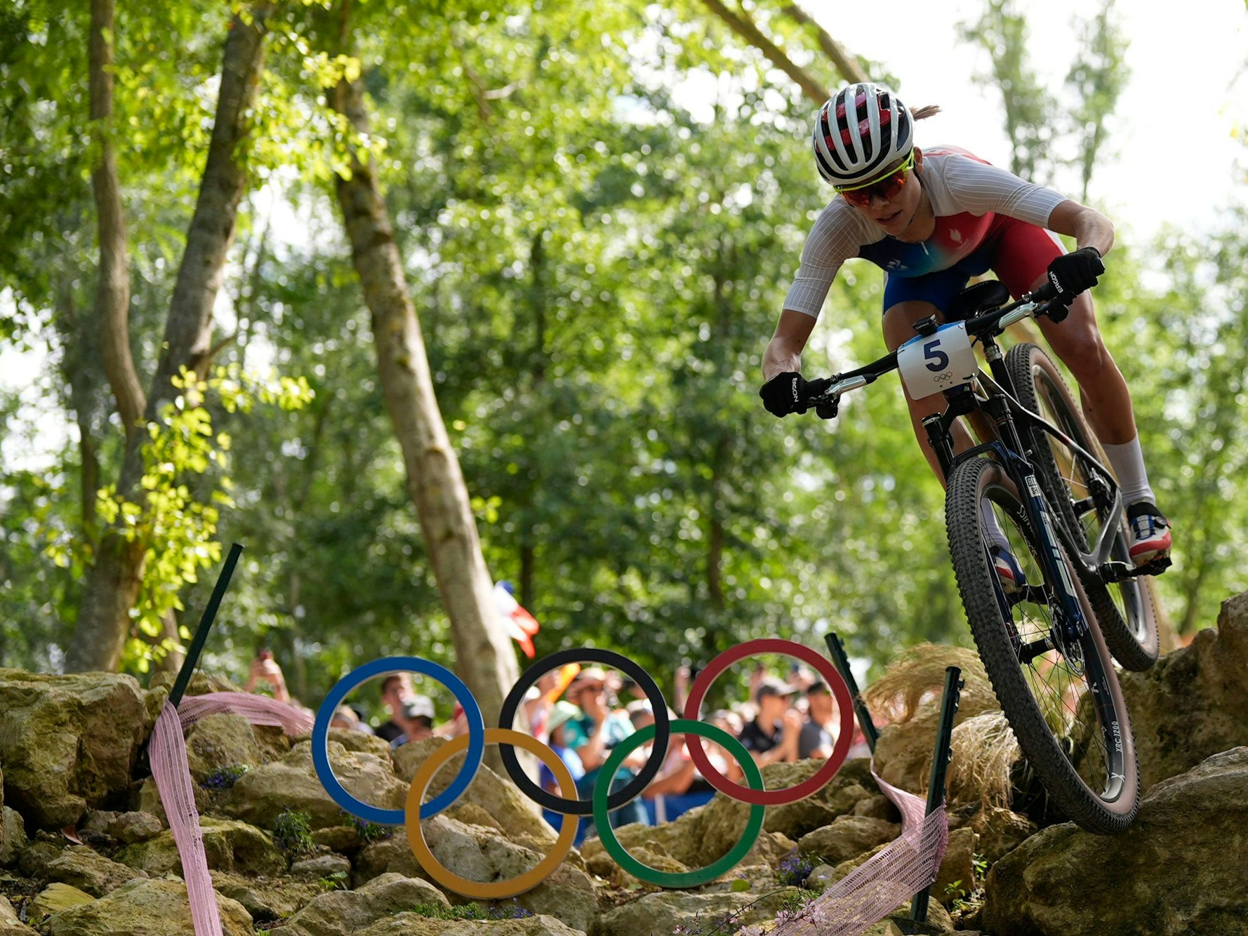 Loana Lecomte fährt auf dem Mountainbike durchs Gelände.