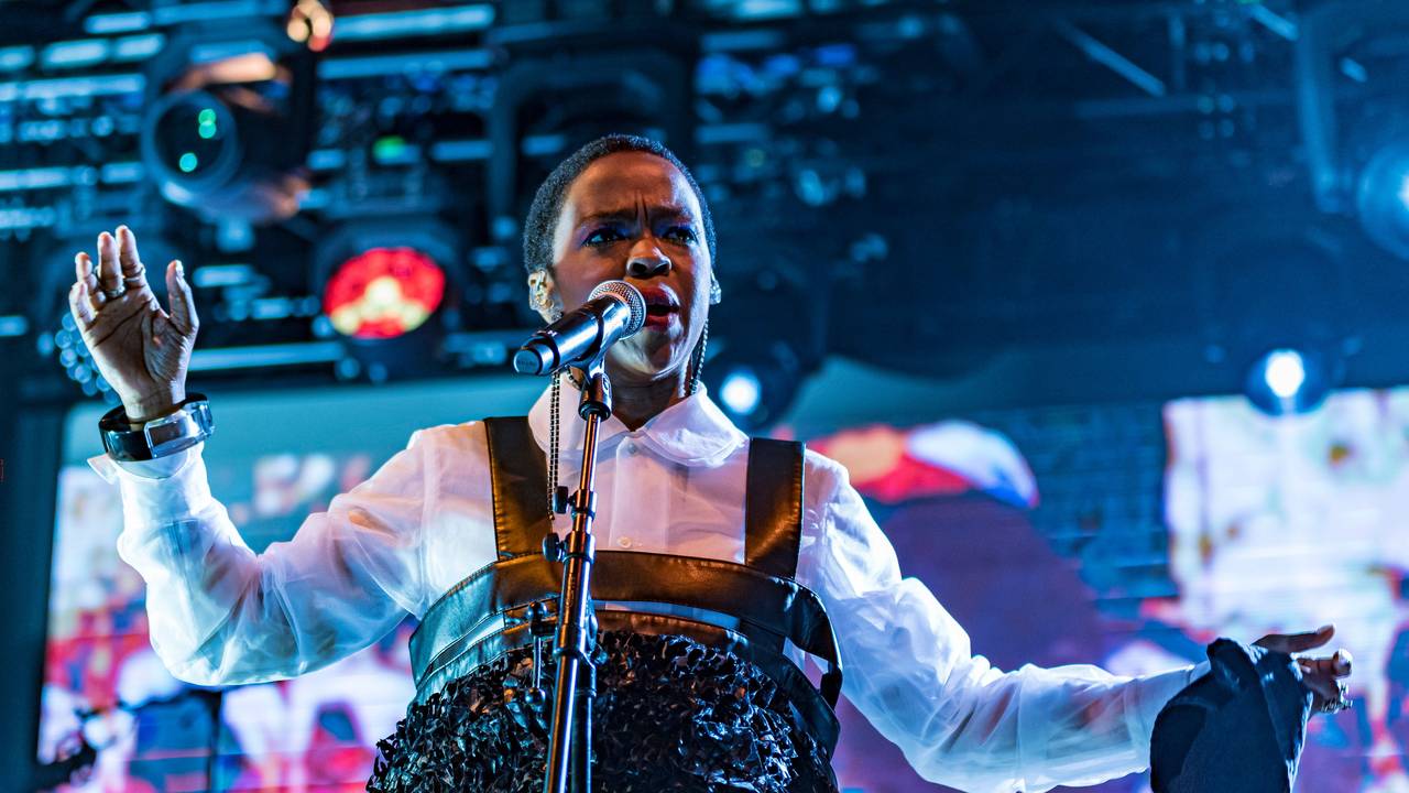 Lauryn Hill singt auf einer Bühne.