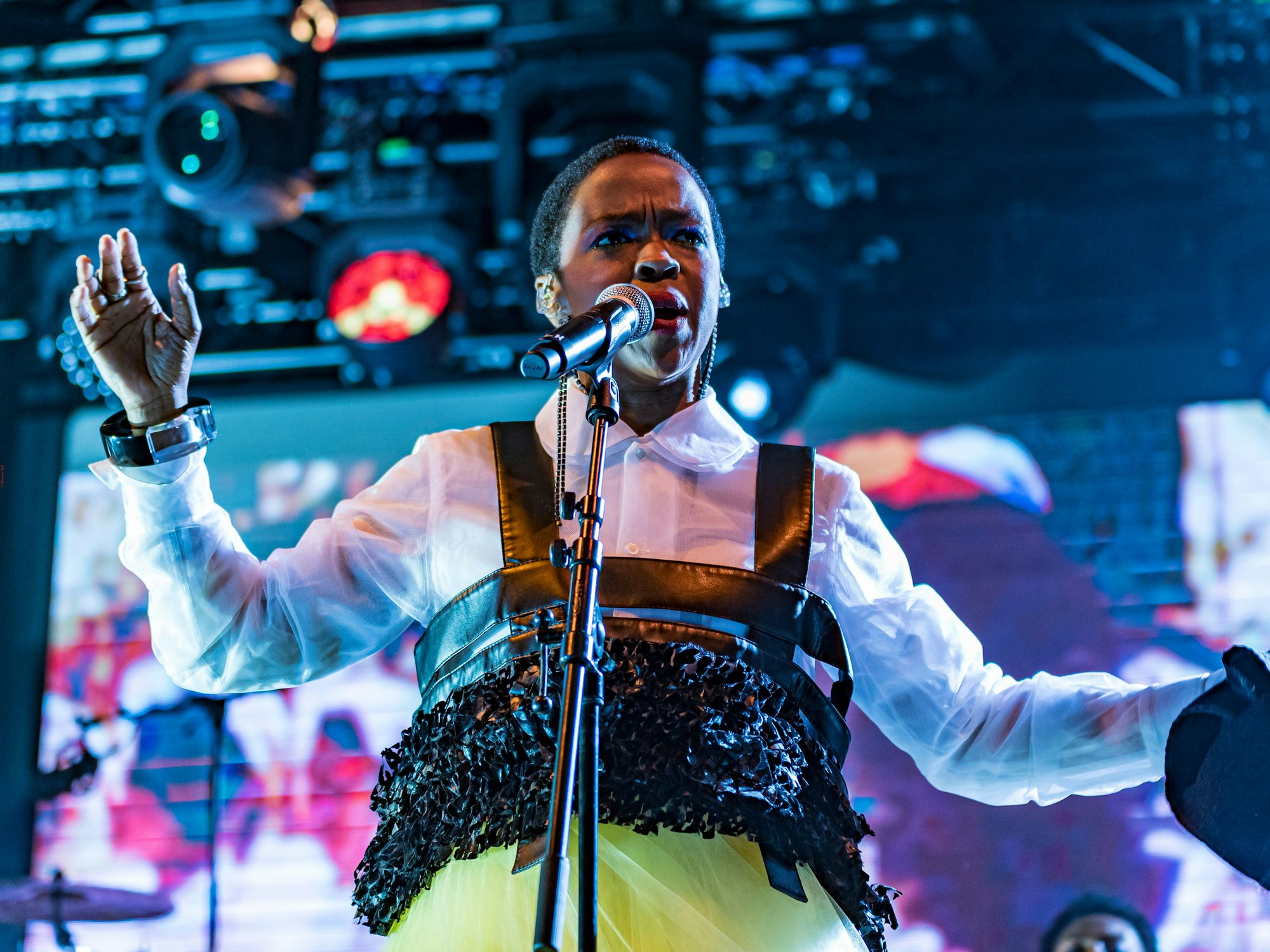 Lauryn Hill singt auf einer Bühne.
