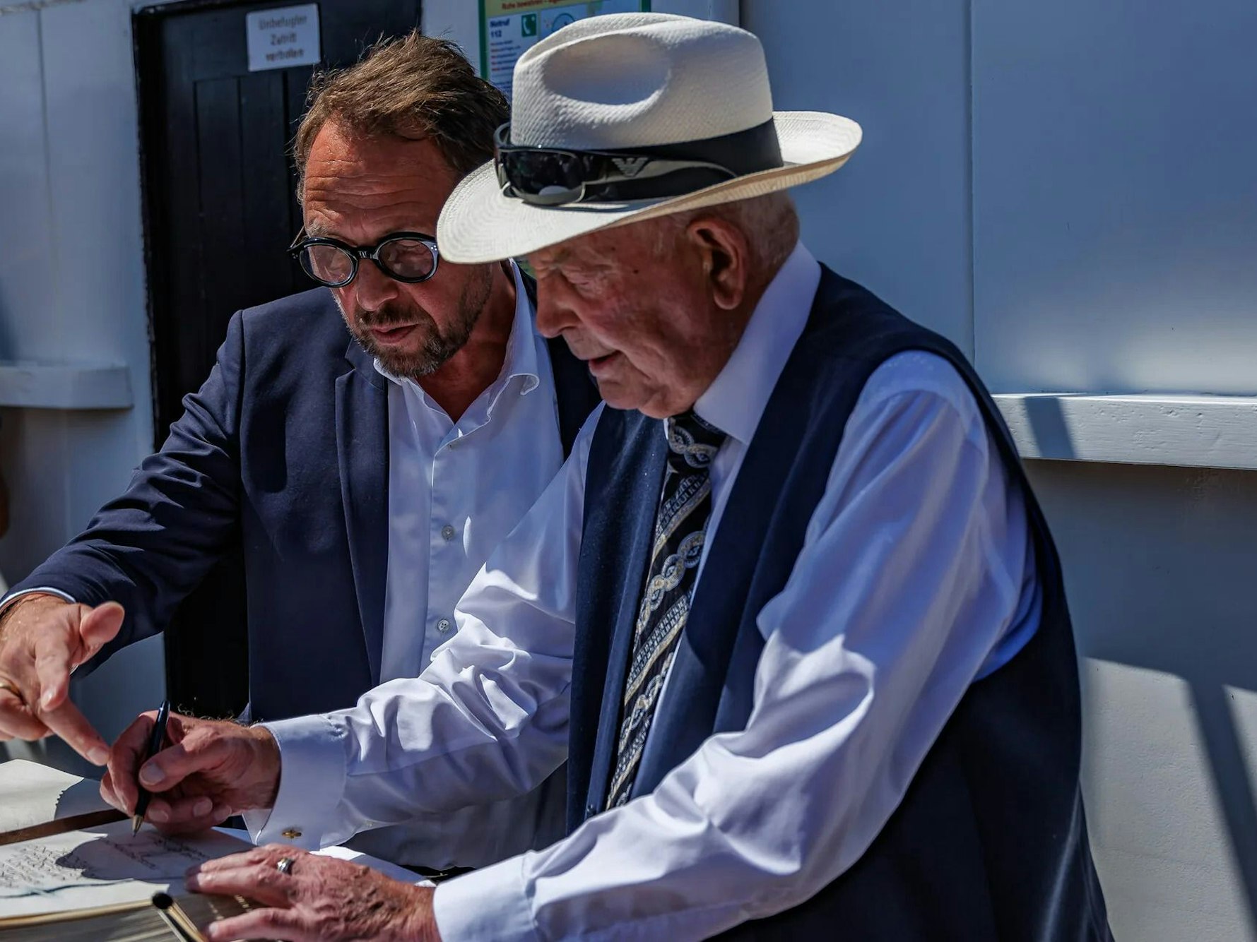 Leverkusens Oberbürgermeister Uwe Richrath hilft Heinz Brinkschulte beim Eintrag ins Goldene Buch.