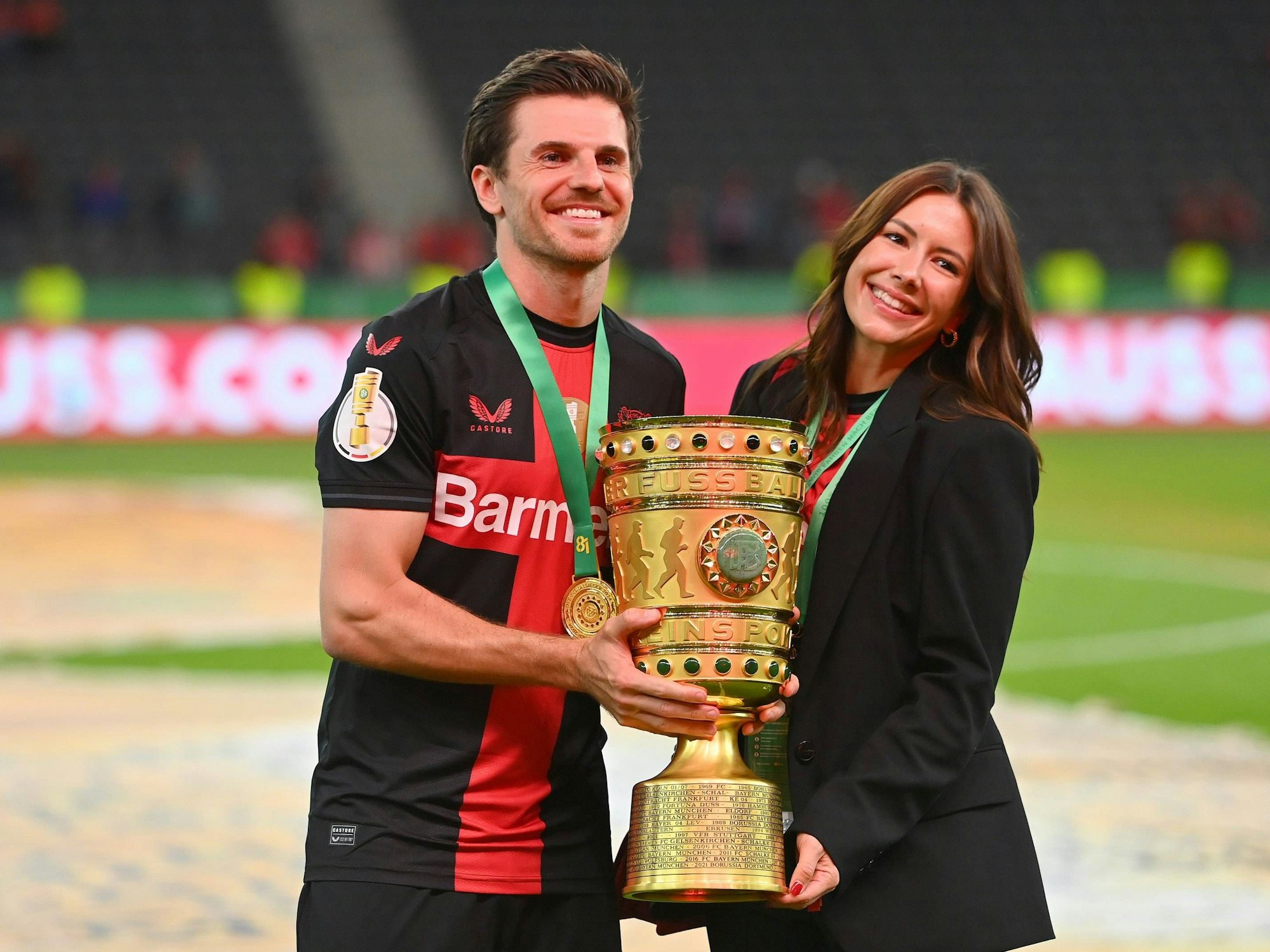 Jonas Hofmann (l.) mit Laura Winter halten gemeinsam den DFB-Pokal in den Händen.