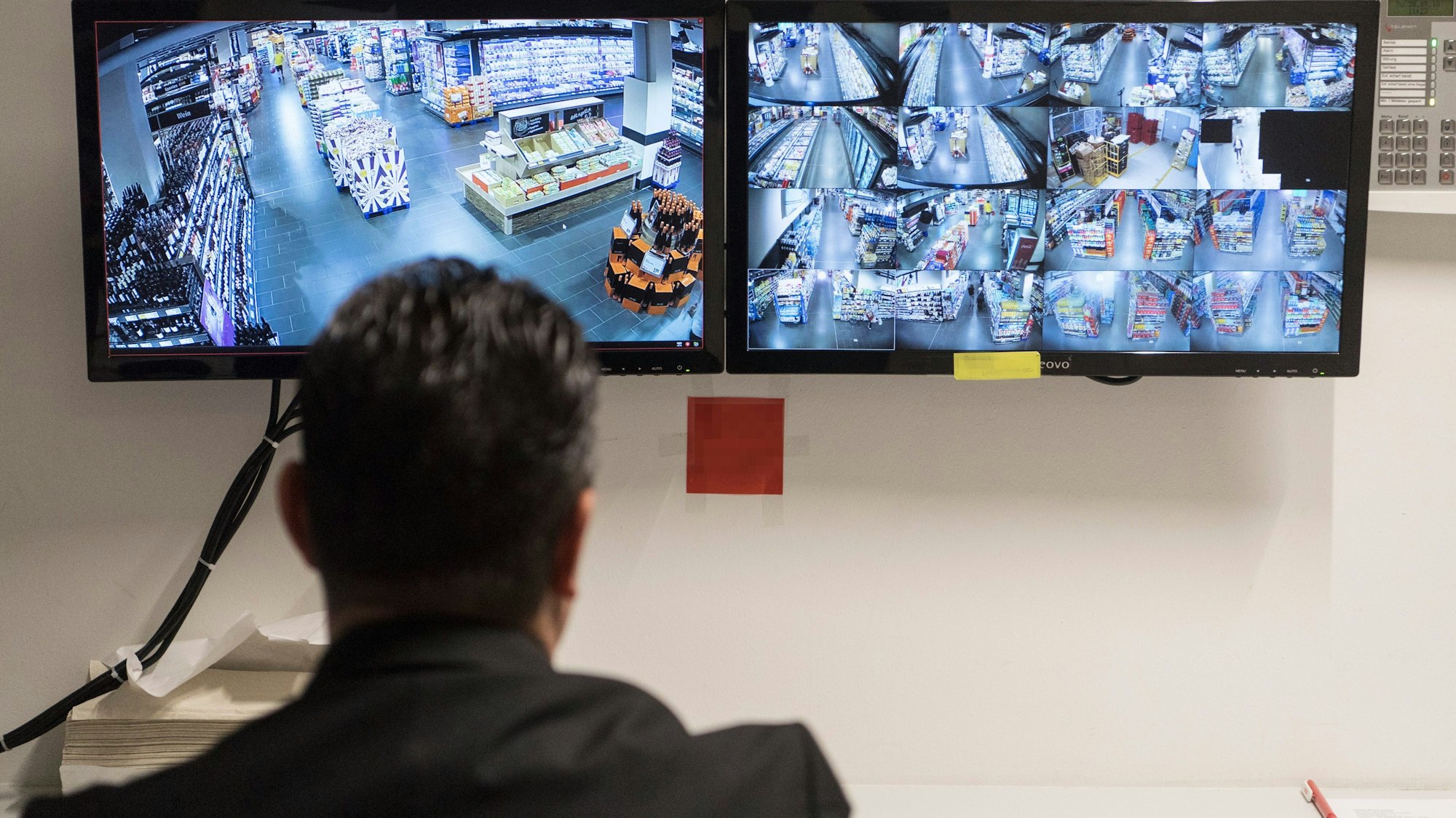 Ein Ladendetektiv sitzt vor Überwachungsmonitoren eines Supermarktes in Wiesbaden.