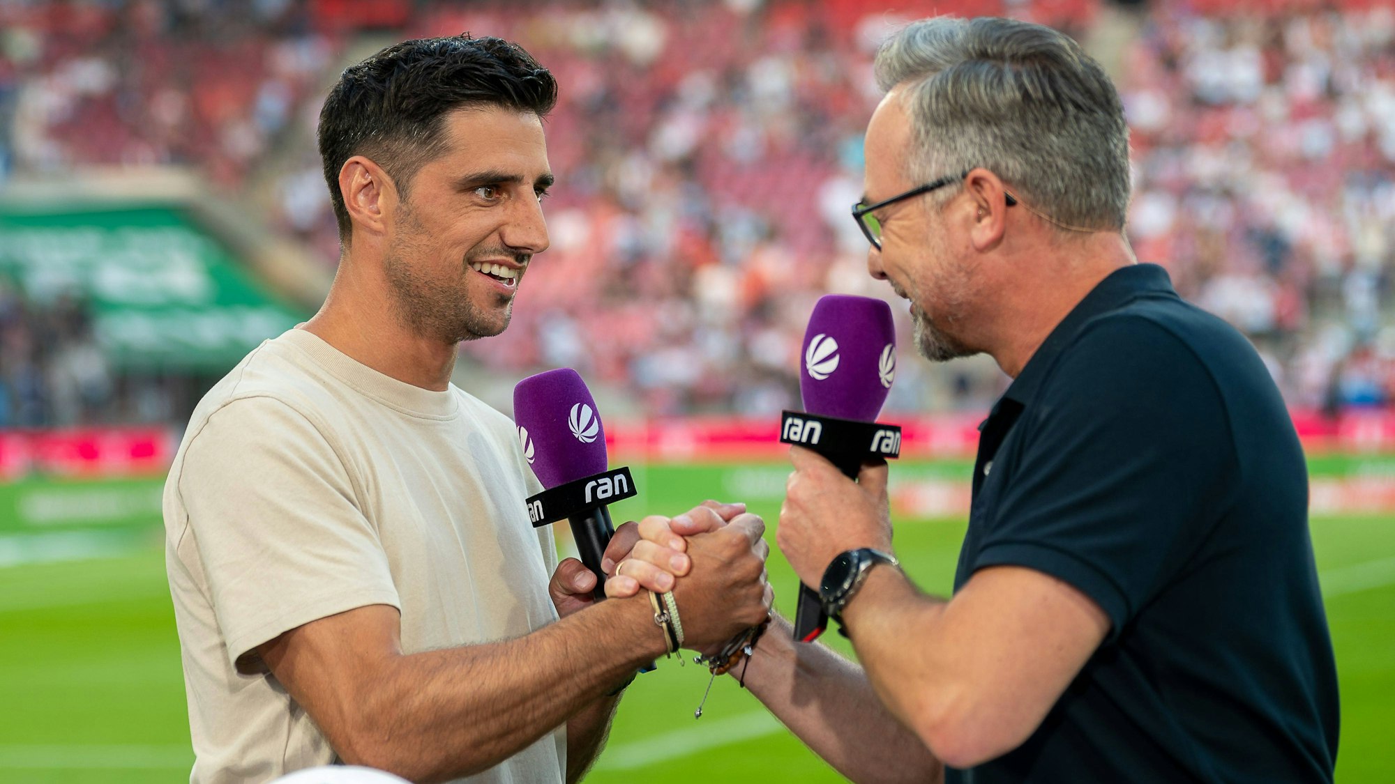 Sat.1-Moderator Matthias Opdenhövel (r.) bei der Live-Übertragung zum Saison-Auftakt der 2. Bundesliga in Köln mit Experte Lars Stindl. Zeitweise bekam das Duo weiteren Besuch.