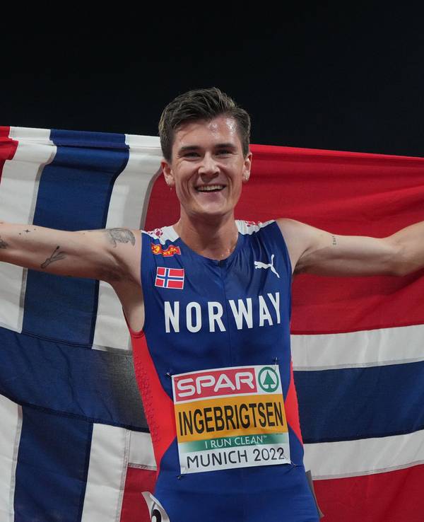 Jakob Ingebrigtsen jubelt mit Norwegen-Flagge.