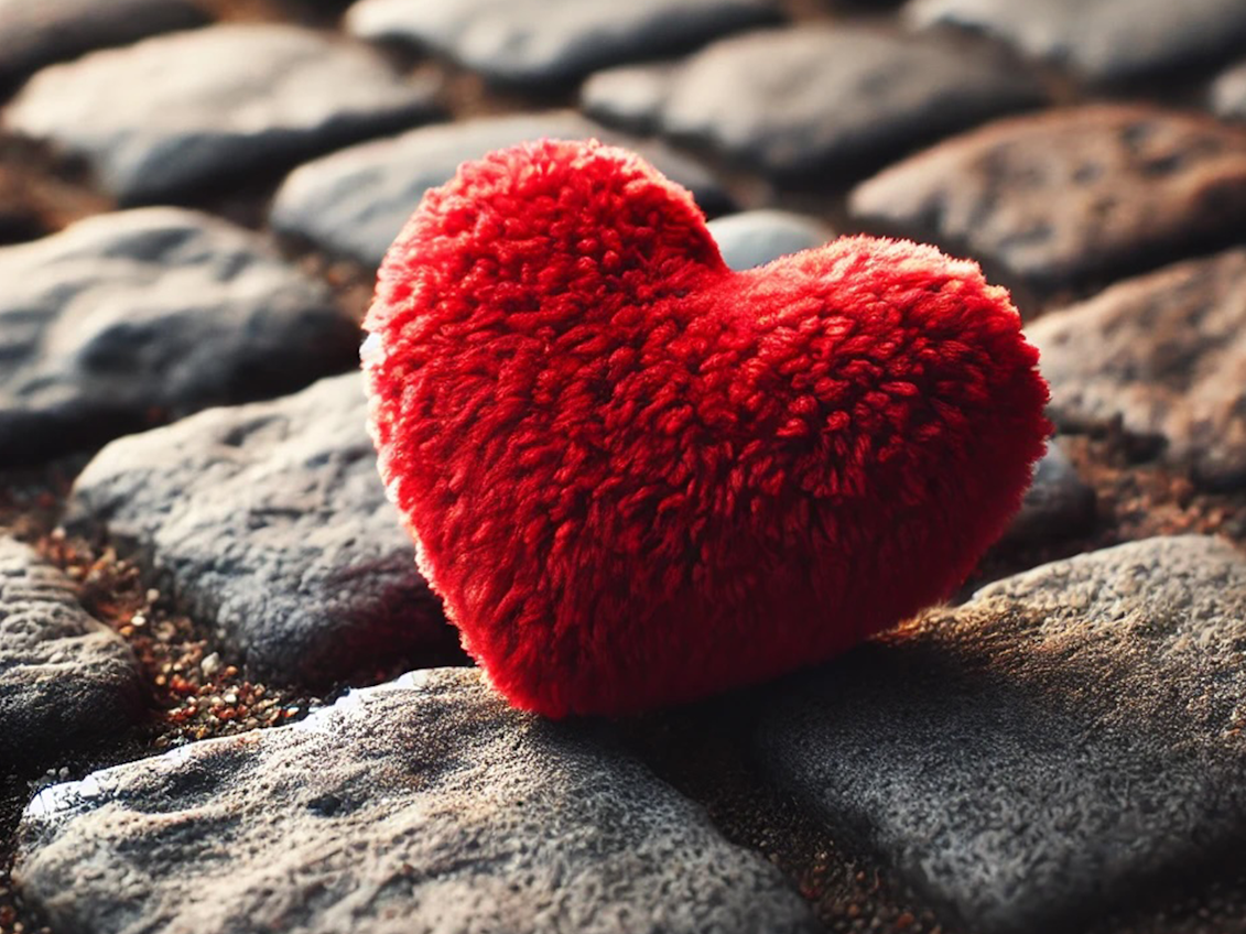 Rotes Stoffherz liegt auf einem Steinboden