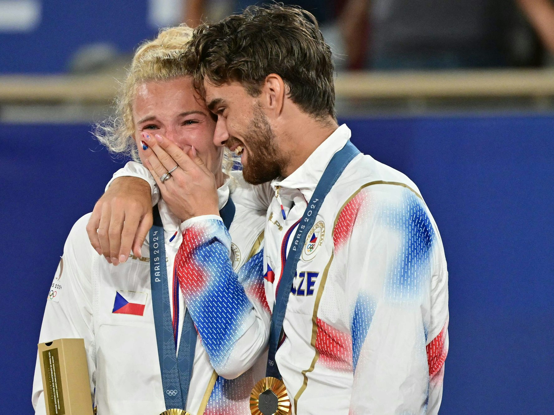 Tomas Machac umarmt bei der Siegerehrung Katerina Siniakova.