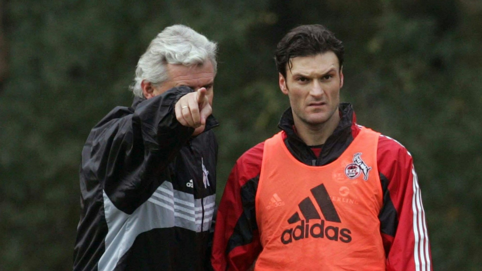 Uwe Rapolder zeigt Abwehr-Raubein Alpay im Training des 1. FC Köln am 22. November 2005 wo’s langgeht.