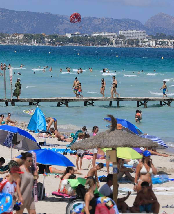 Menschen sonnen sich am Playa de Muro.