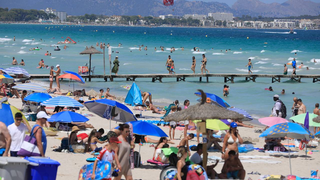 Menschen sonnen sich am Playa de Muro.