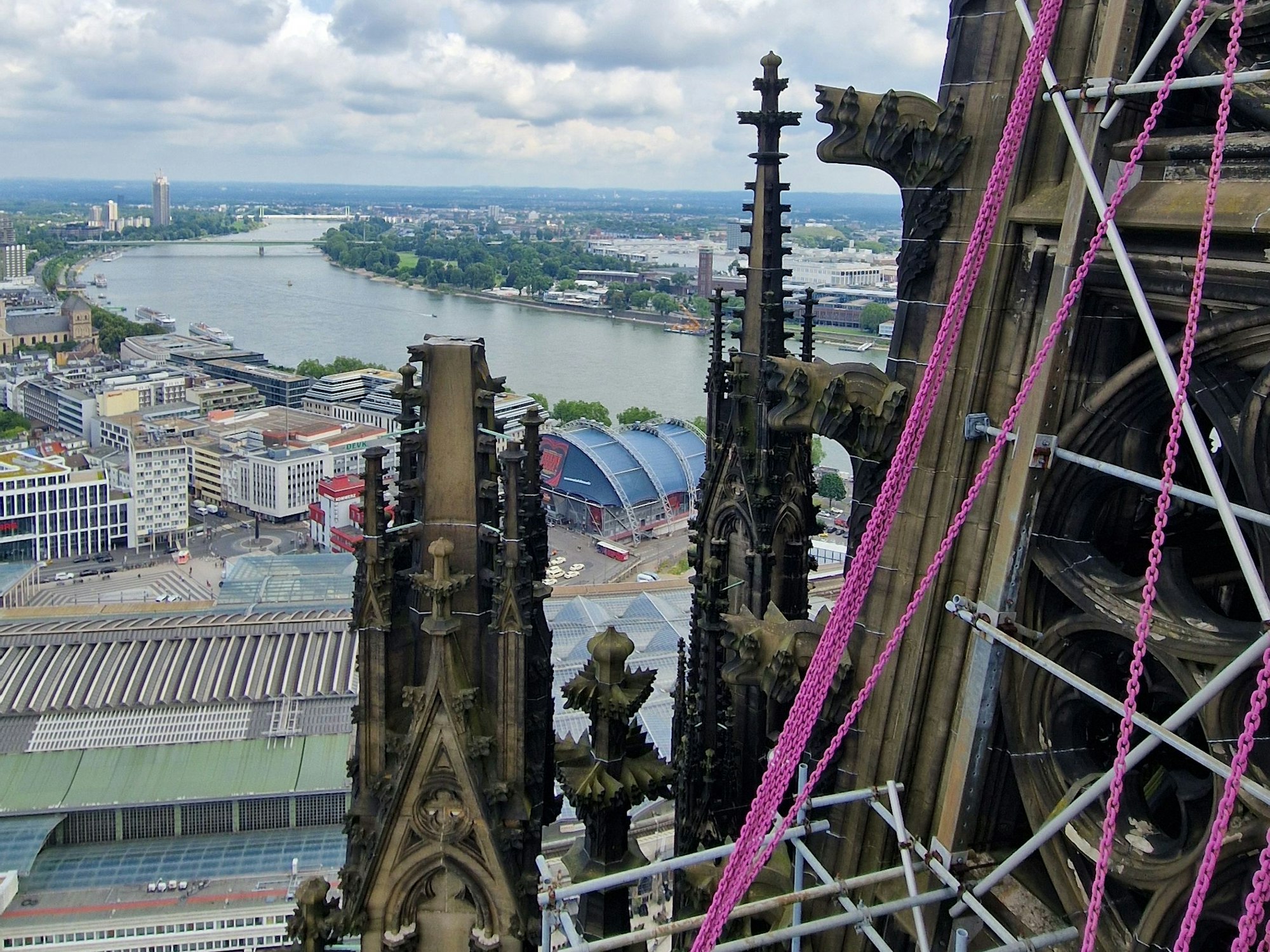 Rosa Schwerlastketten hängen am Kölner Dom.