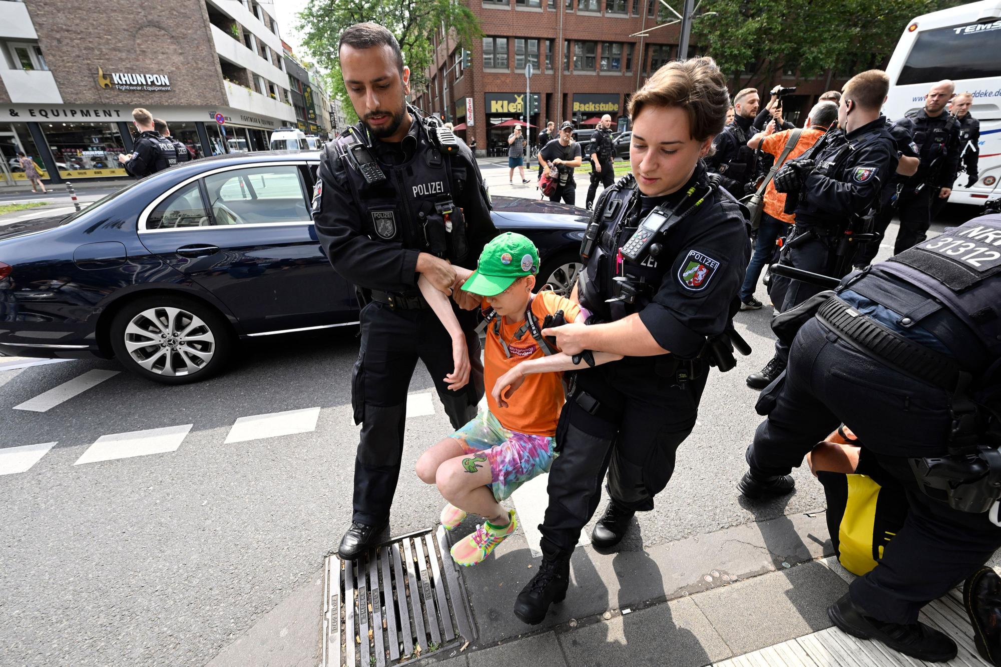 Polizisten ziehen Klimaaktivisten „der letzten Generation“ in der Innenstadt von der Straße, nachdem diese versucht hatten, eine Straße zu blockieren, um auf ihre Angelegenheit aufmerksam zu machen.