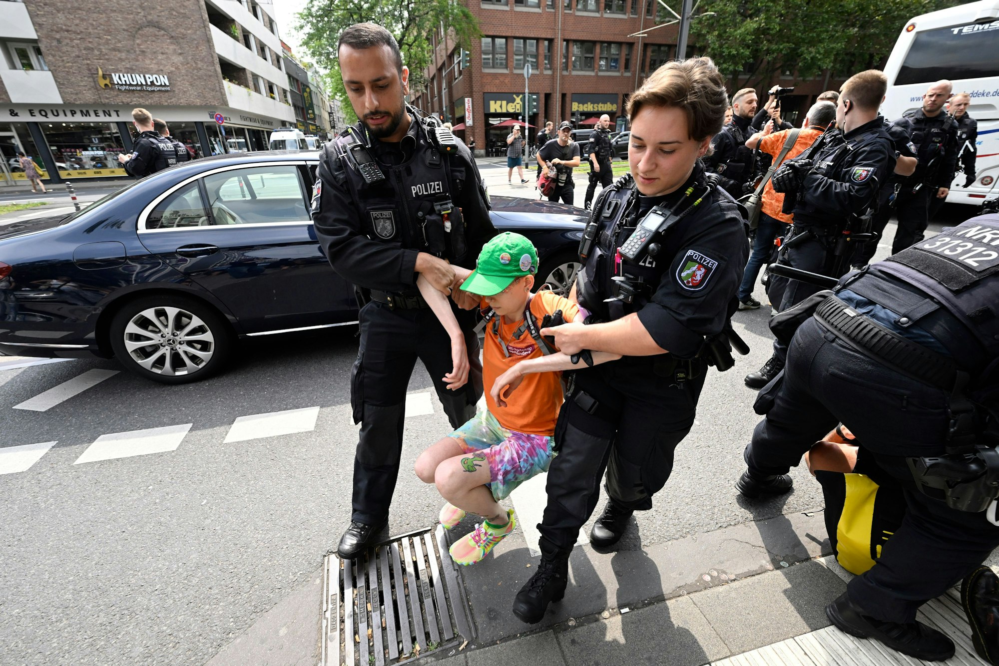 Polizisten ziehen Klimaaktivisten „der letzten Generation“ in der Innenstadt von der Straße, nachdem diese versucht hatten, eine Straße zu blockieren, um auf ihre Angelegenheit aufmerksam zu machen.