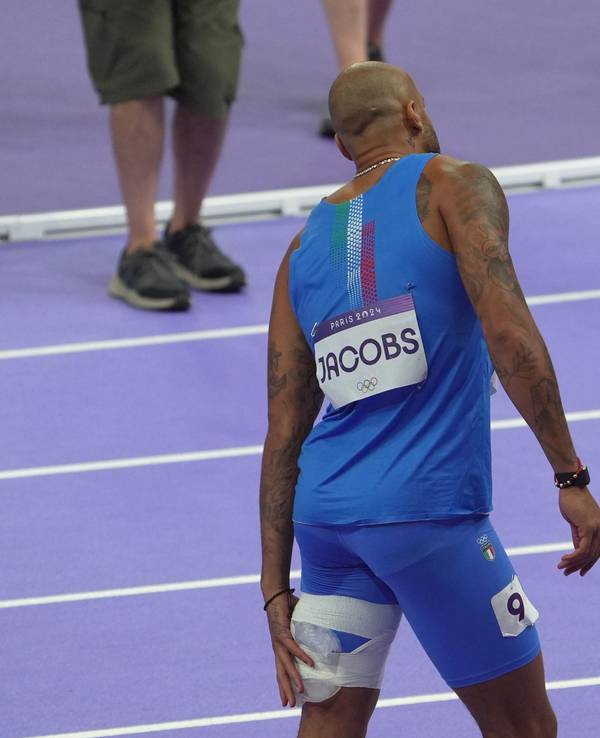 Marcell Jabocs humpelt mit dick bandagiertem und mit Eis gekühltem Oberschenkel nach dem Olympia-Rennen über 100 Meter aus dem Stadion.