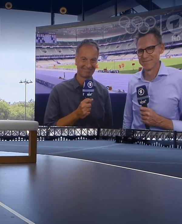 Alexander Bommes im Olympia-Studio der ARD, im Hintergrund sind Claus Lufen und Frank Busemann aus dem Stade de France zugeschaltet.