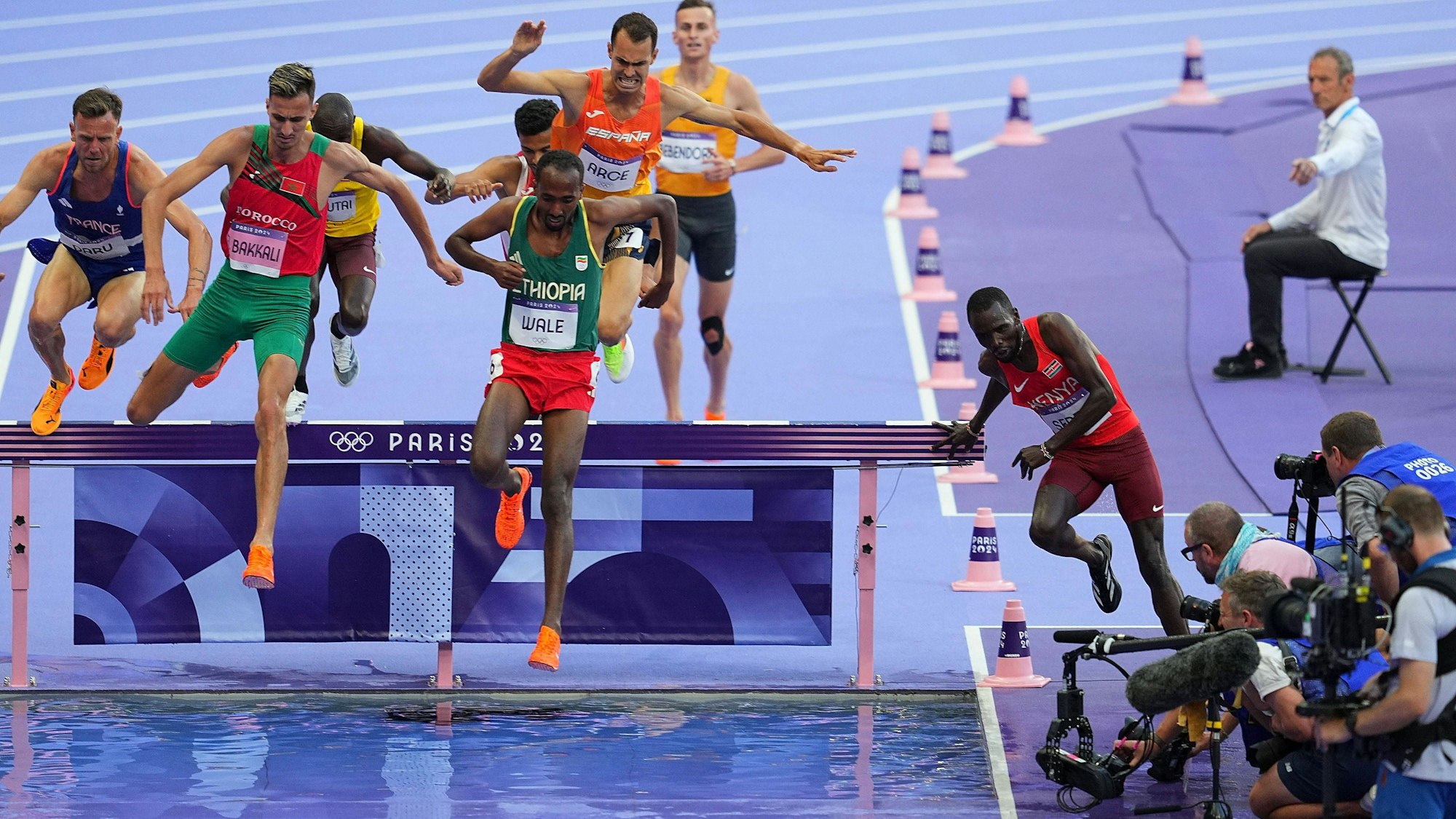 Amos Serem (r.) läuft beim Olympia-Hindernislauf nach einem Schubser im Feld versehentlich am Hindernis vorbei