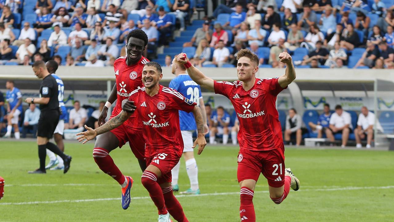 Von l. nach r. Joshua Quarshie, Matthias Zimmermann und Tim Rossmann laufen jubelnd über den Fußballplatz.