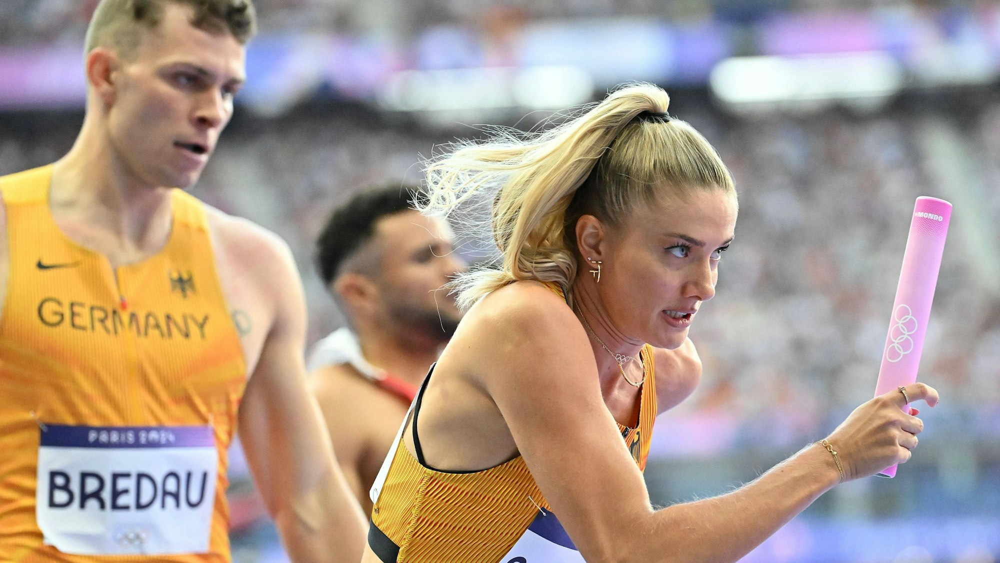 Alica Schmidt läuft mit dem von Jean Paul Bredau übergebenen Staffelstab.