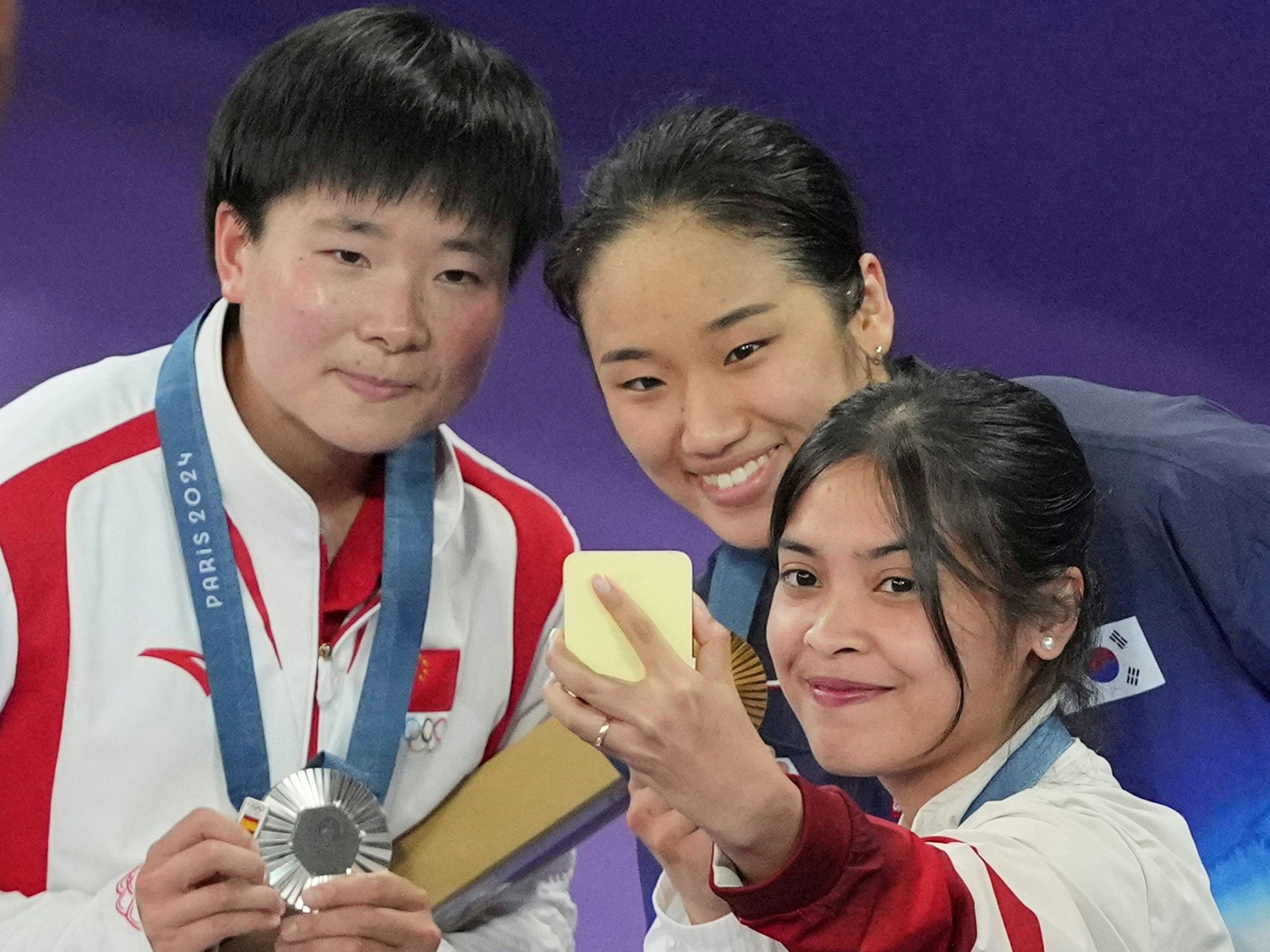 Kleine, aber feine Geste: He Bingjiao (l.) bei der Siegerehrung mit An Se Young und Gregoria Mariska Tunjung. In der rechten Hand hält sie einen kleinen Spanien-Pin.