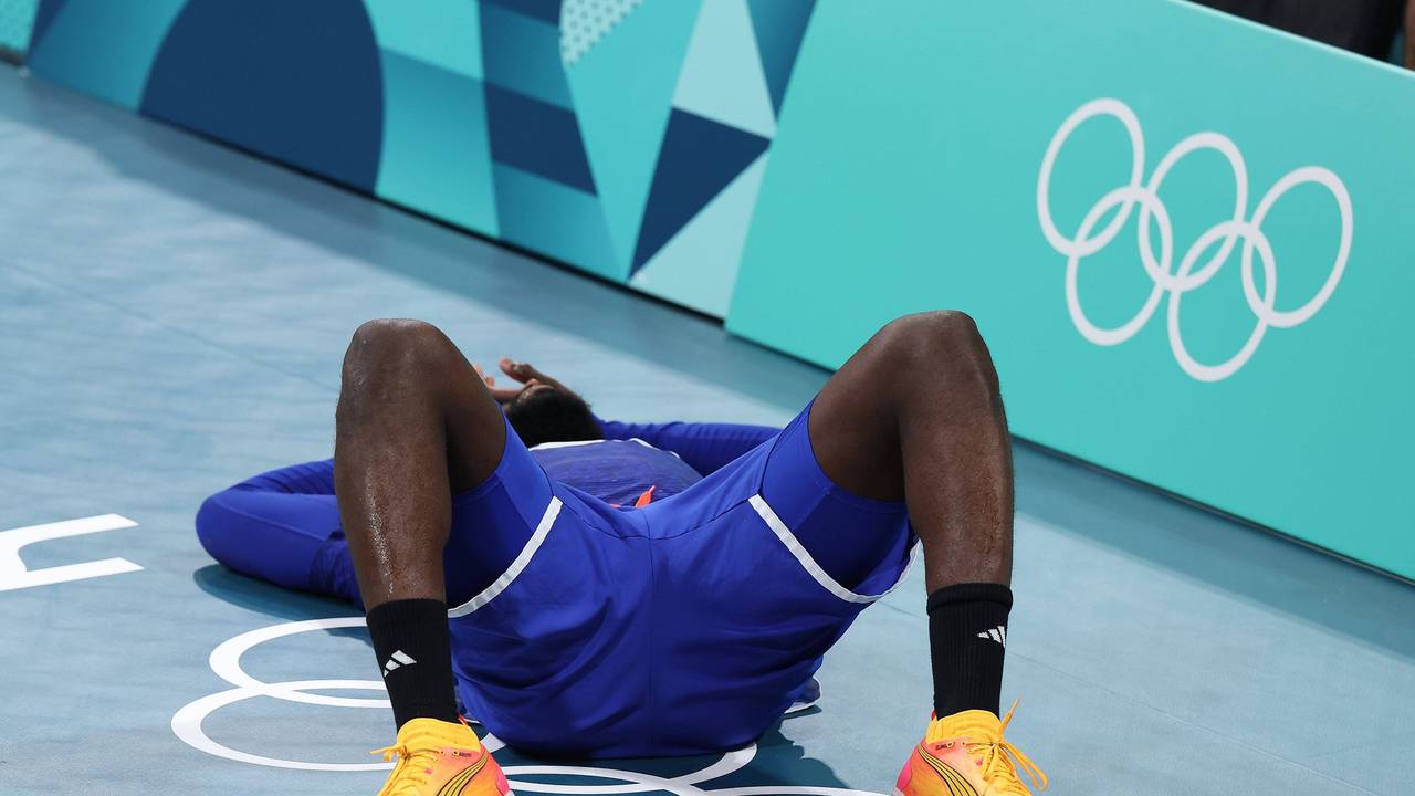 Französischer Handballer liegt enttäuscht auf dem Boden.