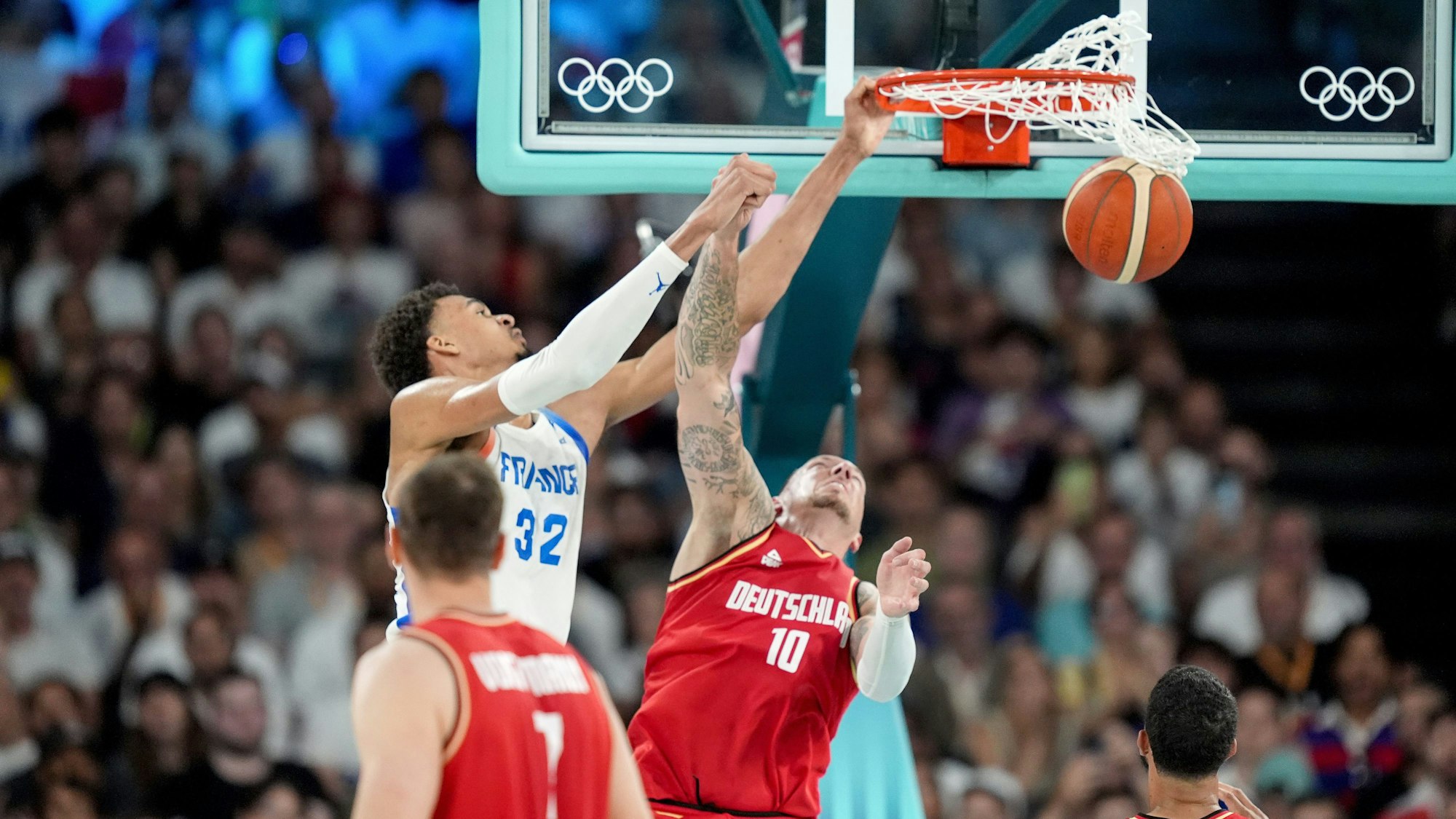 Deutschlands Daniel Theis (r) und Frankreichs Victor Wembanyama l/hinten) beim engen Duell um den Ball im Basketball-Halbfinale bei Olympia am Donnerstag (8. August 2024).