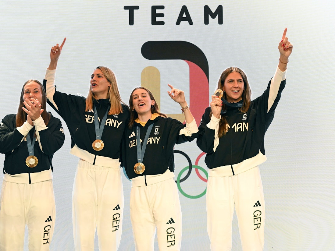 Die deutschen Basketballerinnen Svenja Brunckhorst (l-r), Sonja Greinacher, Elisa Mevius und Marie Reichert feiern am 6. August 2024 mit der Goldmedaille im Deutschen Haus.