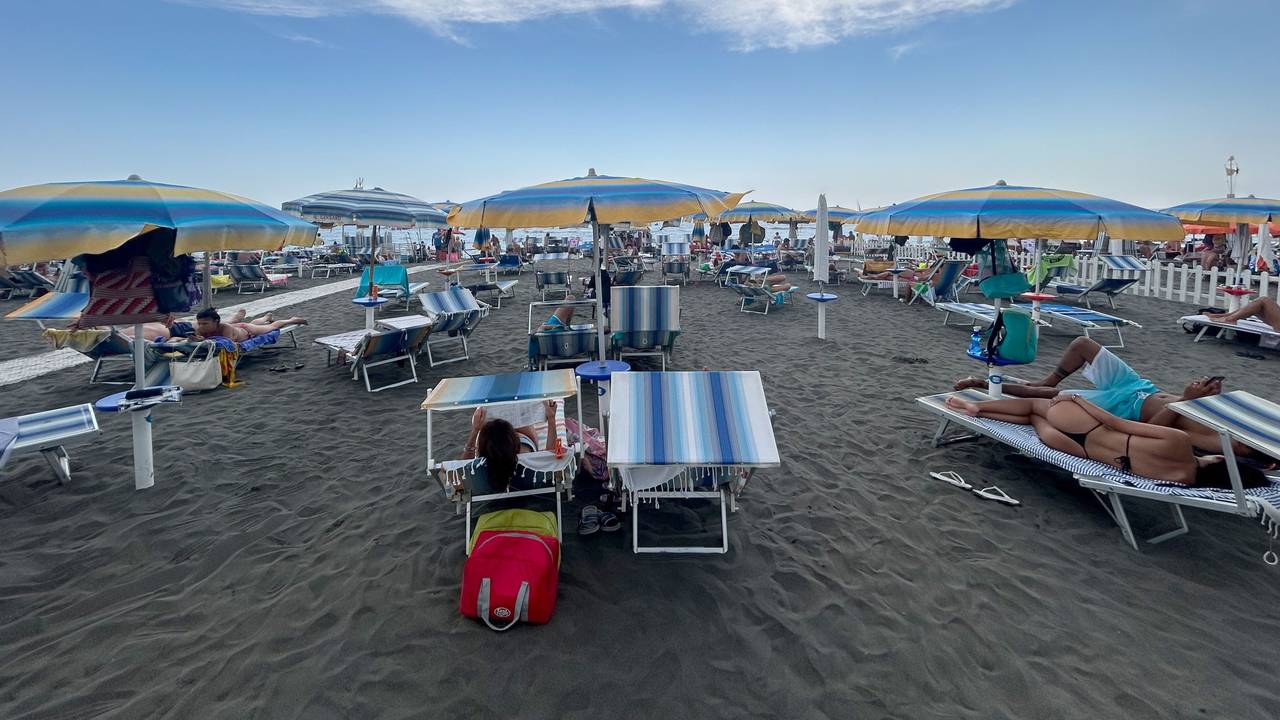 Menschen liegen auf Strandliegen unter Sonnenschirmen am Mittelmeer in Ostia in der Nähe von Rom. Am Freitag (9. August 2024) findet ein großer „Sonnenschirm-Protest“ statt.