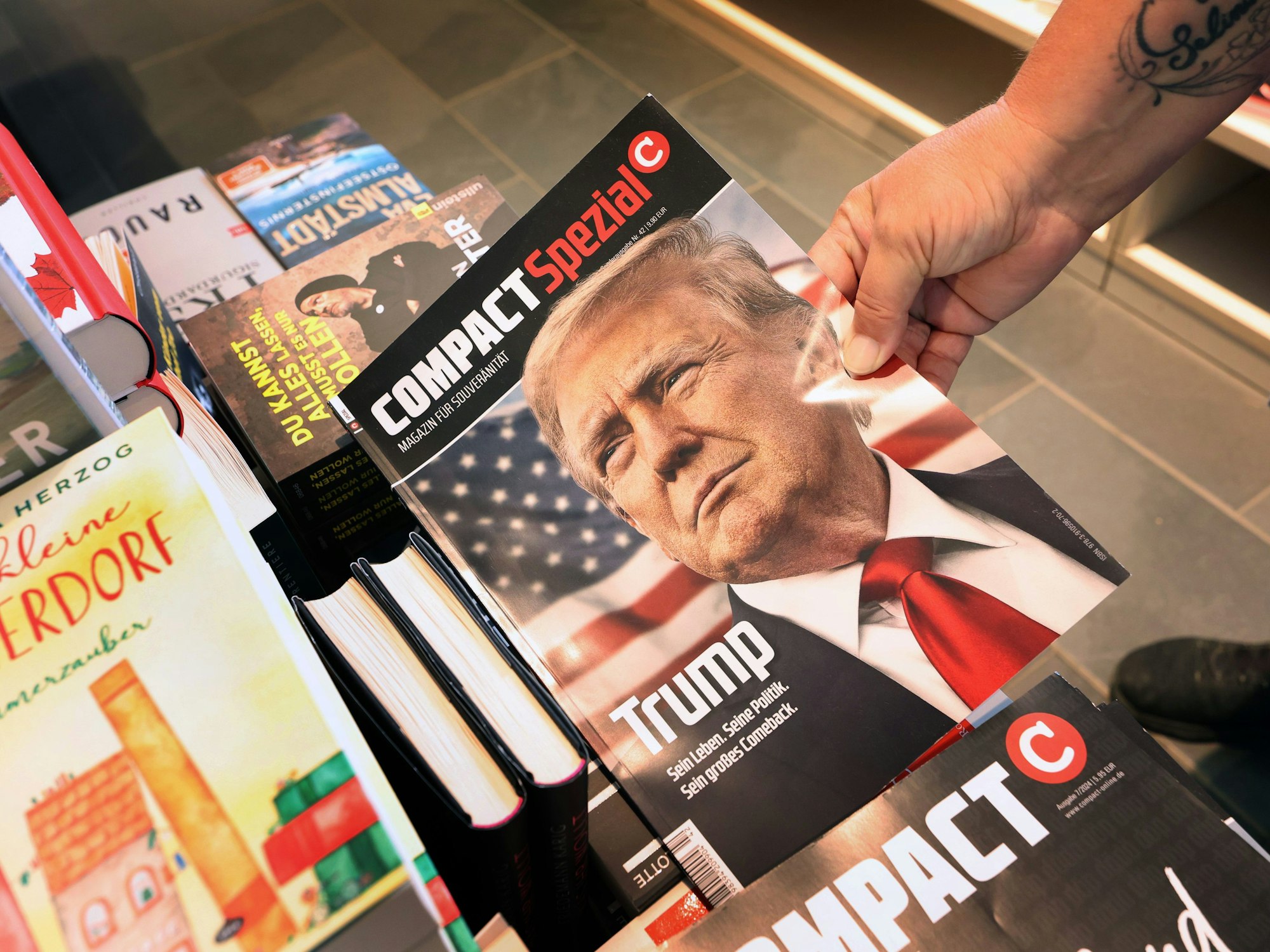 Eine Mitarbeiterin einer Bahnhofsbuchhandlung hält eine Ausgabe des Magazins „Compact“, um es danach aus dem Sortiment zu nehmen.